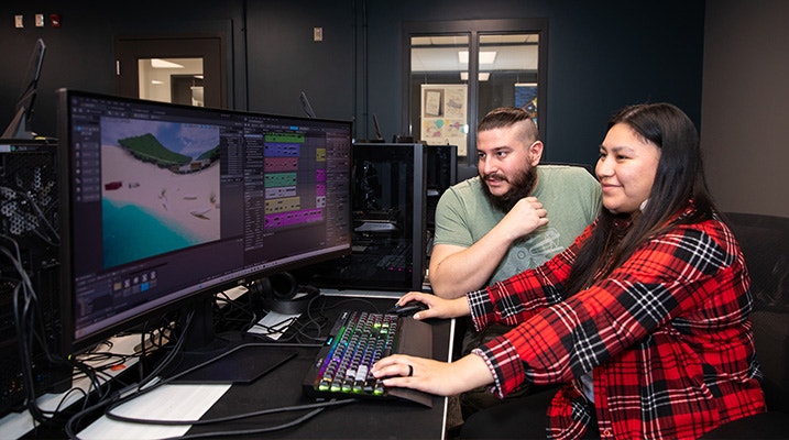 Canadore Game Development students Mathew Gauthier and Amy Noah sitting in front of a computer